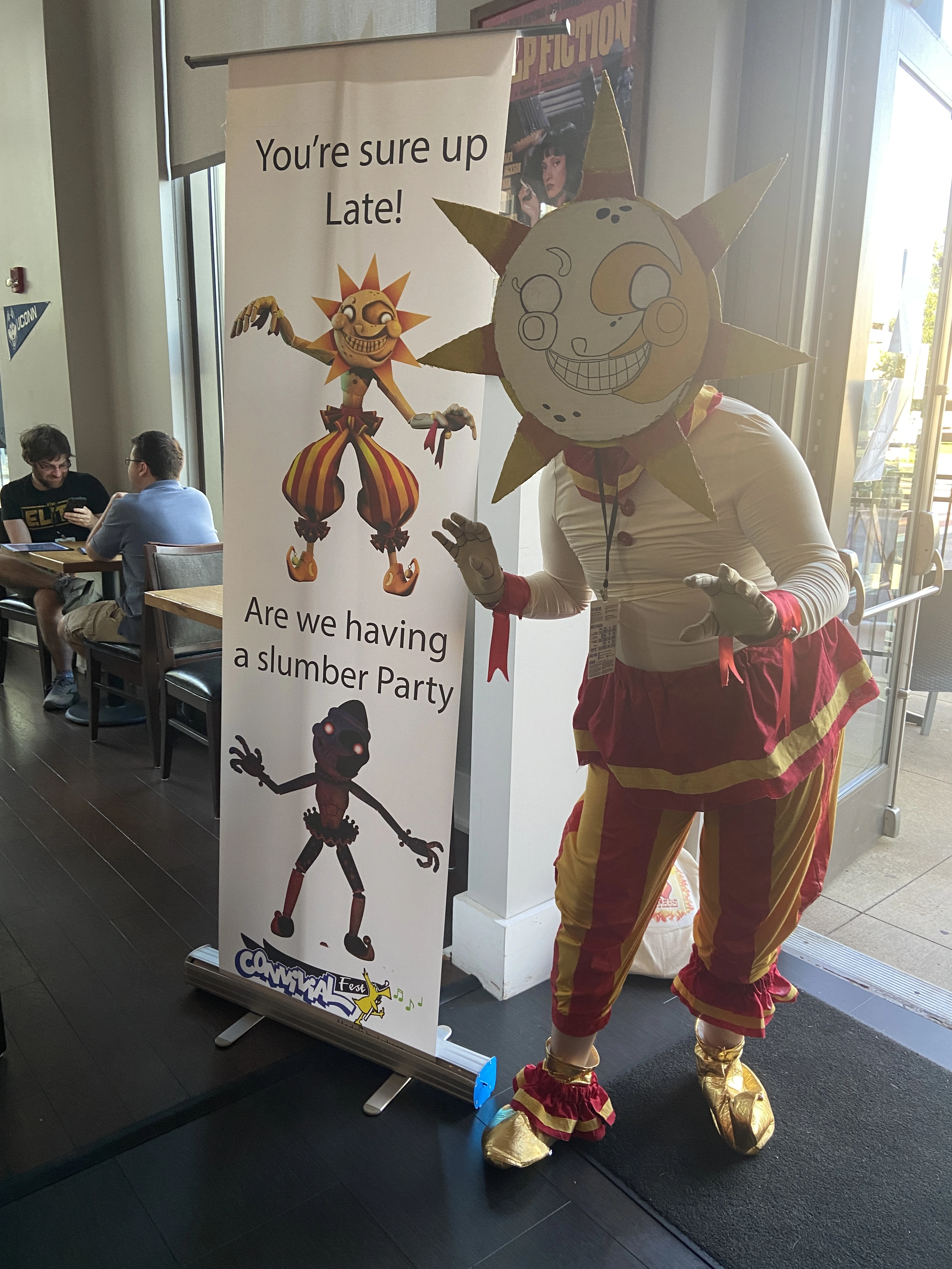 Me in my sun costume next to a picture of Sun at a bar